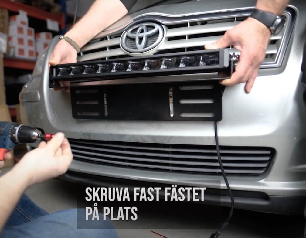 Skruva fast fästena för ledrampen bakom nummerplåten