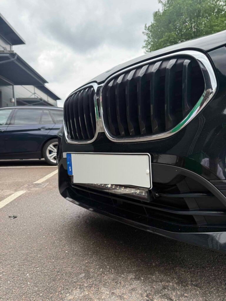 Svart BMW med LED-ramp monterad under registreringsskylten